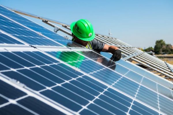 man working on a solar panel monitoring system