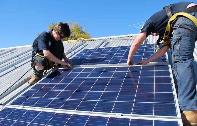 two men installing solar power system on the rooftop