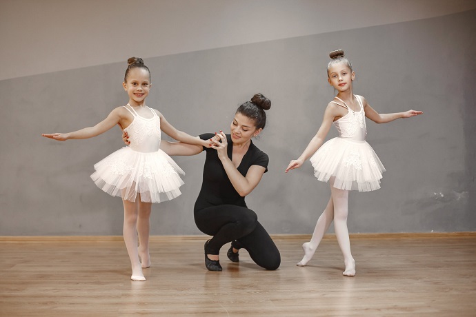 picture of a woman and two little girls dancing ballet wearing classical tutus 