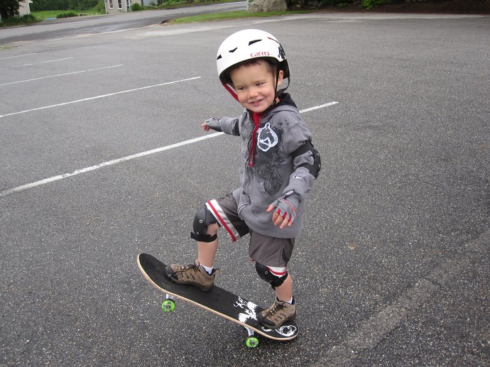 picture of a boy riding a skateboard with a helmet